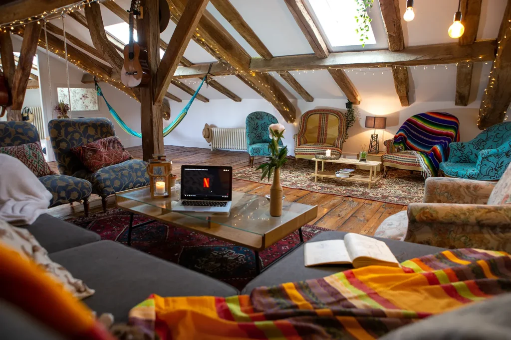 Architecture intérieure : salon sous combles avec poutres apparentes et mobilier dépareillé à Bayonne par ADIO.