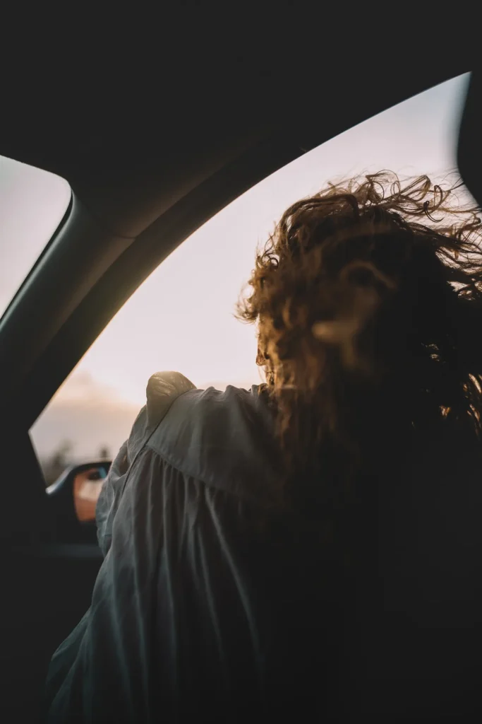 Photos des backstage : femme aux cheveux bouclés de dos dans un véhicule de production aux Bardenas par ADIO.