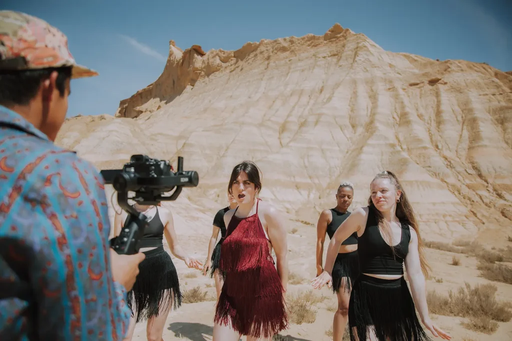 Photos des backstage : caméraman filmant Victoria Picone en robe rouge aux Bardenas avec matériel Sony par ADIO.
