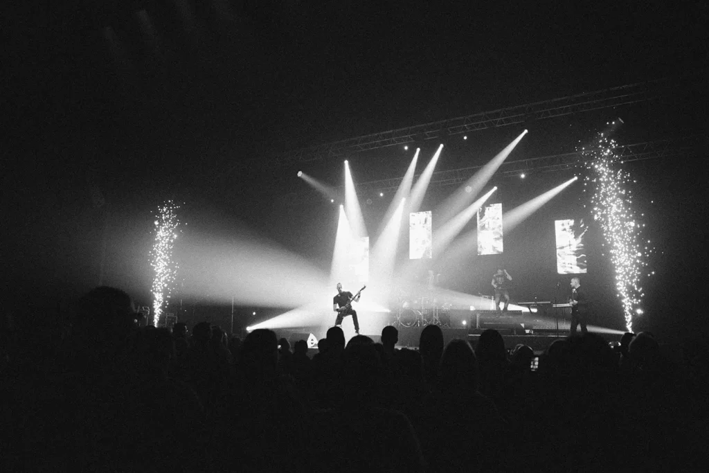 Concert : étincelles pyrotechniques et silhouettes d'artistes sur scène à Bordeaux par ADIO
