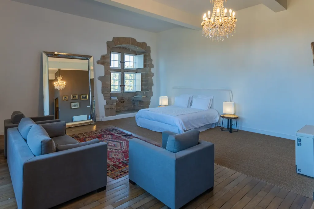 Chambre luxueuse avec parquet, grand miroir et lustre, Studio ADIO Maison Belzunce à Bayonne.