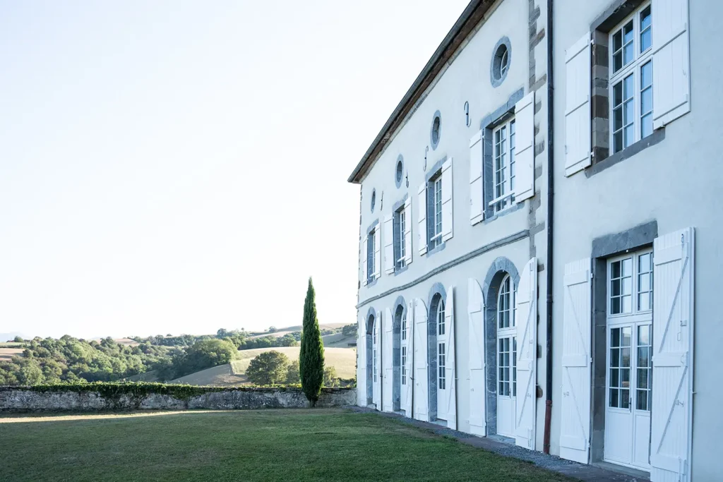 Façade épurée de la Maison Belzunce avec cyprès d'Italie et arches, design Studio ADIO, Pays Basque.