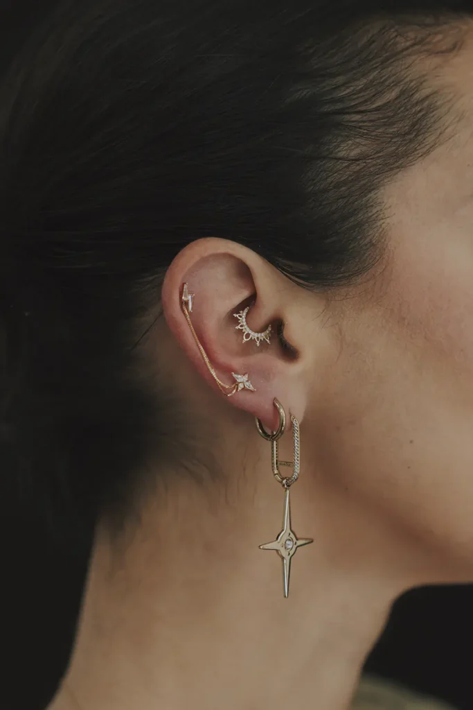Gros plan sur une composition de bijoux d'oreilles haut de gamme de la marque Buddha Jewelry posés chez Vauban Piercing à Bayonne, photo par l'agence ADIO.