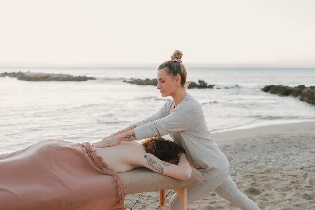 Madérothérapie : séance de massage du dos sur une plage de la Côte Basque pour Maison Galatée par l'agence ADIO.
