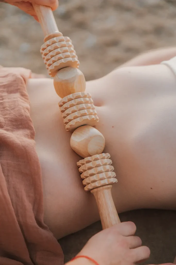 Madérothérapie : utilisation d'un rouleau à picots en bois sur le ventre pour Maison Galatée sur la Côte Basque par ADIO.