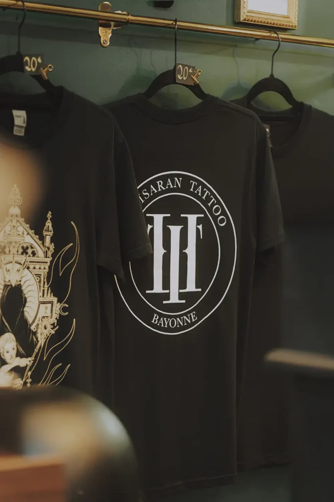 Branding photo : Mise en avant des t-shirts et du logo officiel du studio Hamsaran Tattoo à Bayonne, par l'agence ADIO.