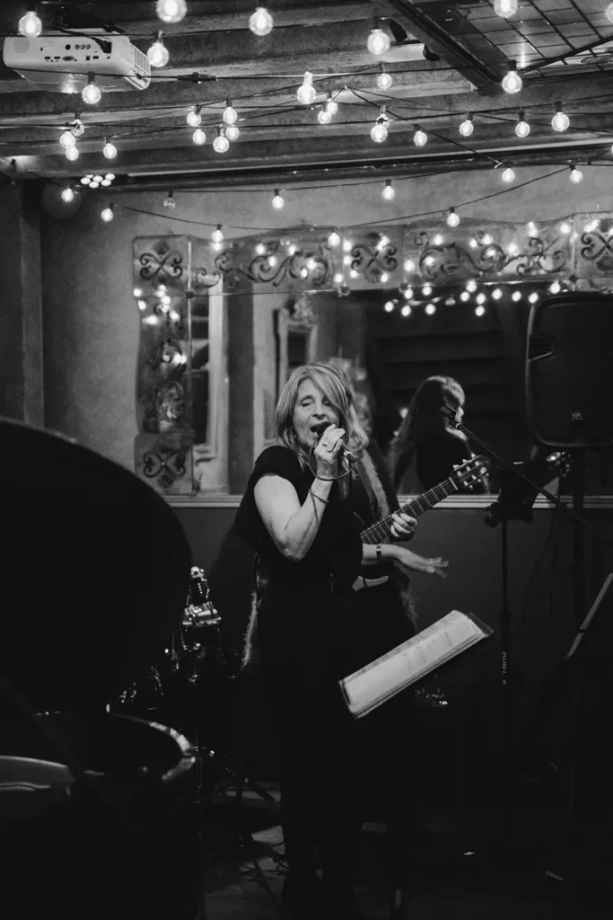 Shooting photo : chanteuse interprétant un morceau sous les guirlandes du Prohibido Jazz Club à Biarritz, capturée par l'agence ADIO.