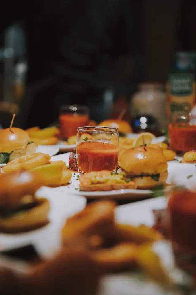 Photographe culinaire : focus sur un repas burger et tapenade au milieu d'une table pour le Prohibido Jazz Club à Biarritz par Studio Adio.