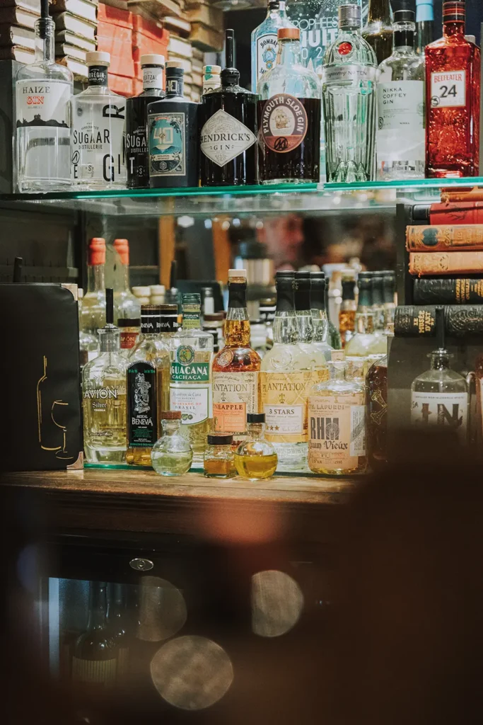 Photographe d'intérieur : étagères d'alcools avec rhum, whisky et gin à l'arrière du bar pour le Prohibido Jazz Club à Biarritz par Studio Adio.