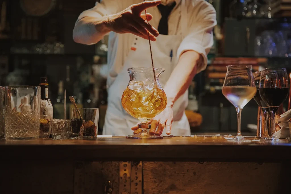 Photographe de métier : serveur préparant un cocktail à la main sur le comptoir du Prohibido Jazz Club à Biarritz par Studio Adio.