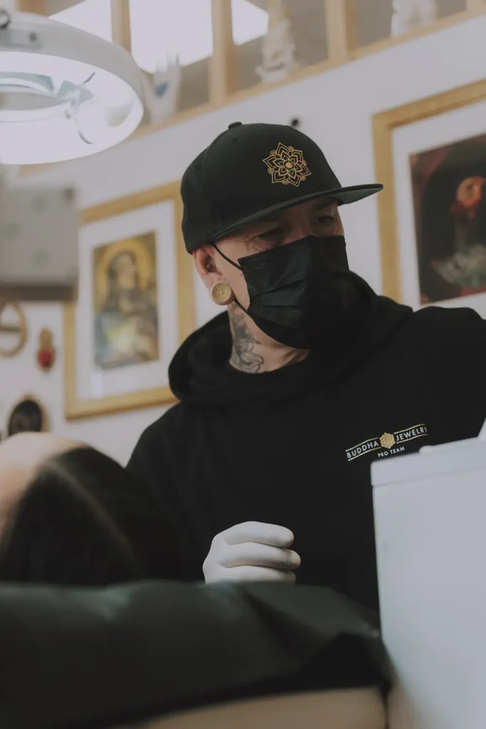 Portrait professionnel : Le perceur Ernest de chez Vauban Tattoo concentré sur son travail lors de l'événement Buddha Jewelry à Bayonne, image par l'agence ADIO.