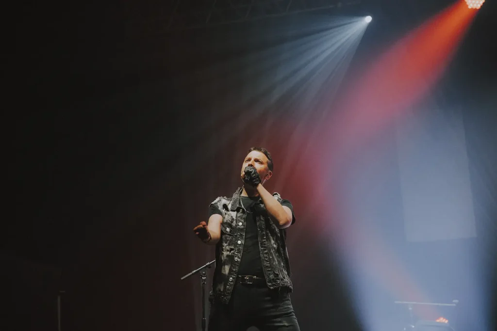 Reportage photo : chanteur de Coverqueen sous les projecteurs à l'Arkéa Arena de Bordeaux par ADIO