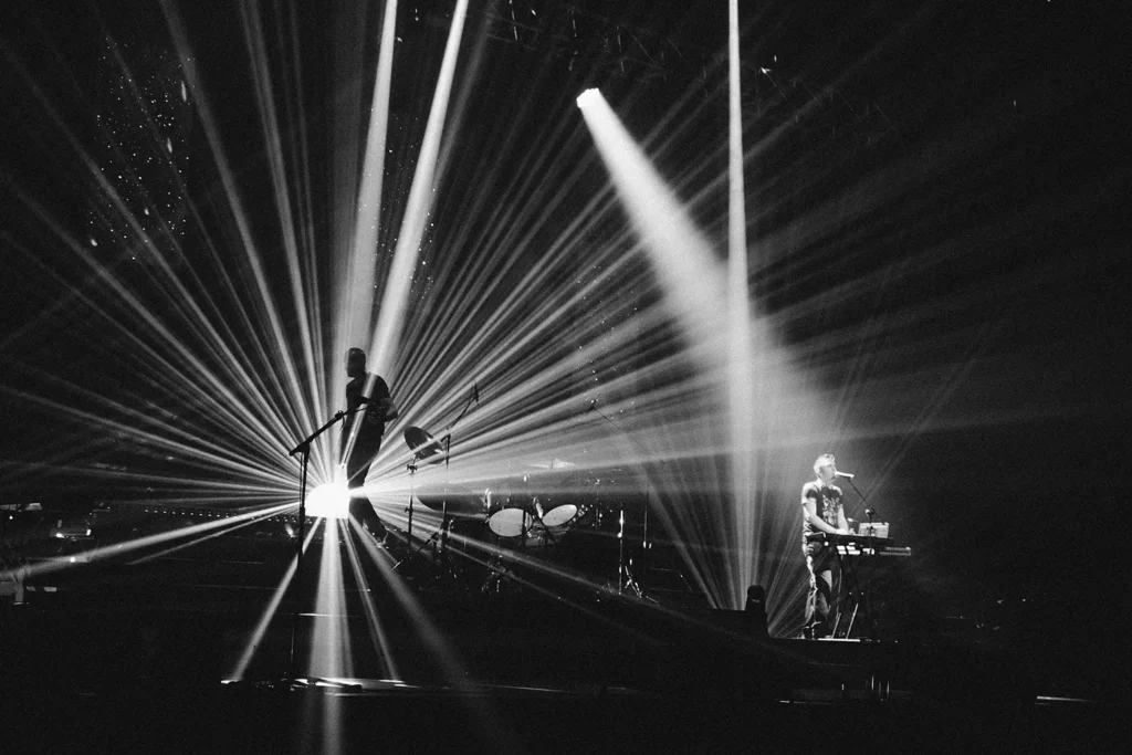 Reportage photo : faisceaux lumineux et musiciens sur la scène de l'Arkéa Arena par l'agence ADIO