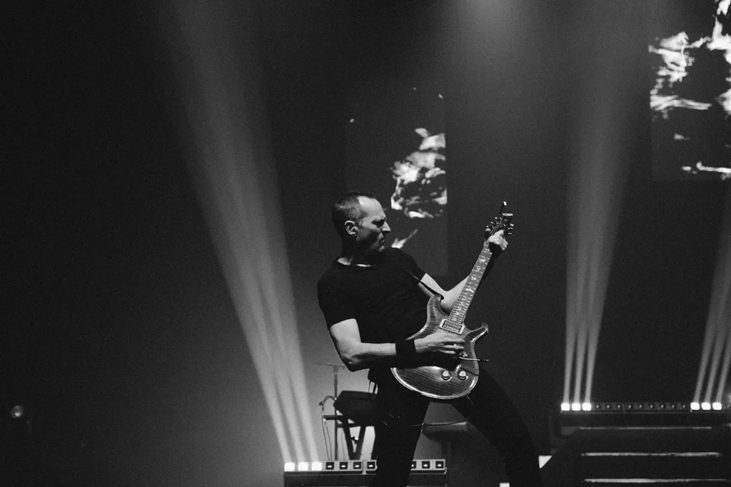 Reportage photo : jeu de guitare passionné sur la scène de l'Arkéa Arena pour Fred Caramia par ADIO
