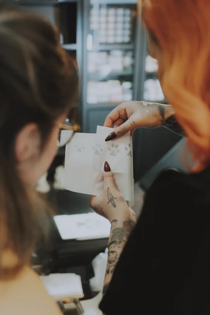 Reportage photo : Vérification du stencil et échange client avant tatouage chez Hamsaran Tattoo à Bayonne, par l'agence ADIO.