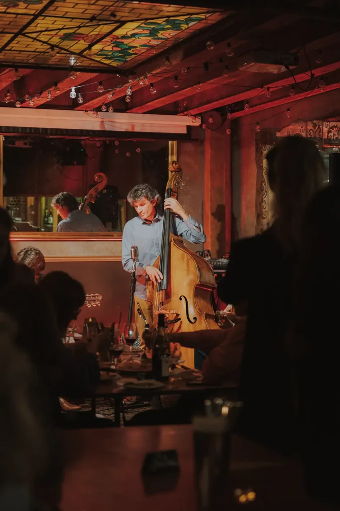 Photographie événementielle : contrebassiste jouant sous un vitrail lors d'un concert au Prohibido Jazz Club à Biarritz par l'agence ADIO.