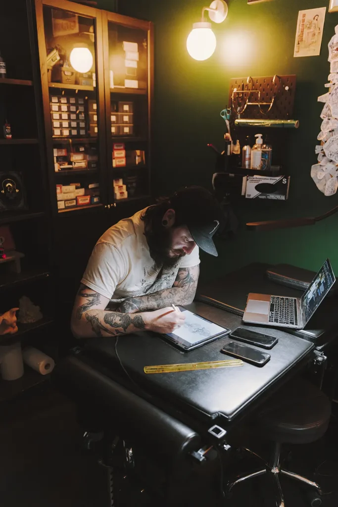 Photographie d'ambiance : Vue d'ensemble de l'espace de création du tatoueur dans son studio à Bayonne, réalisée par l'agence ADIO.