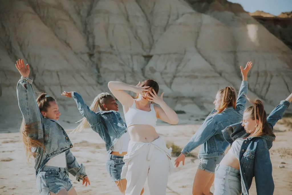 Photos des backstage : Victoria Picone en blanc entourée de ses danseuses en mouvement pour le clip réalisé par ADIO.
