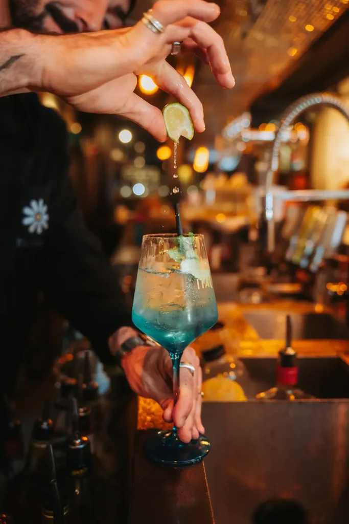 Action bar : Geste vif d'un barman pressant un citron vert dans un verre au Kubata à Bayonne, photo par l’agence ADIO