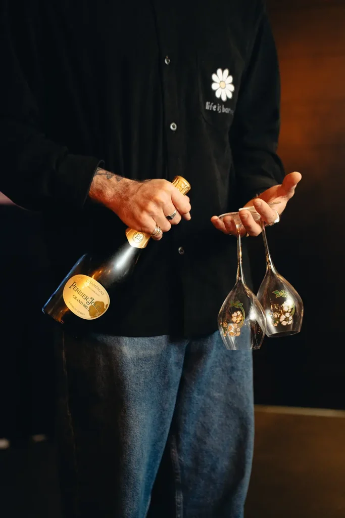 Ambiance : Serveur tenant une bouteille de champagne Perrier-Jouët et des verres au Kubata à Bayonne, photo ADIO