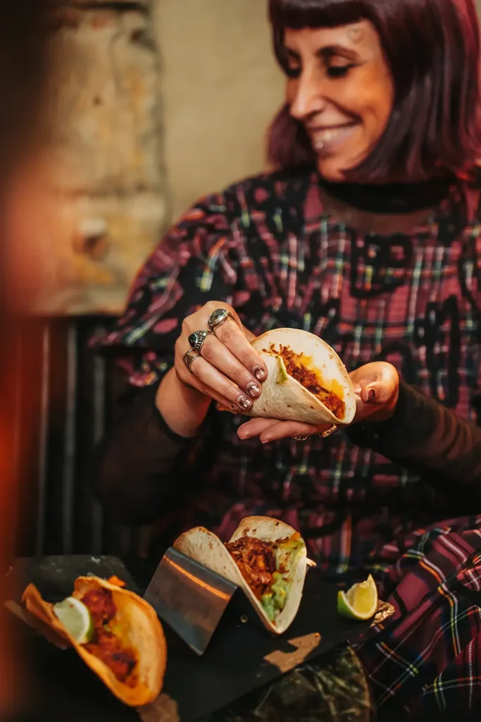 Photographie food : Gros plan sur les mains d'une cliente tenant un taco généreux au Kubata à Bayonne, photo ADIO