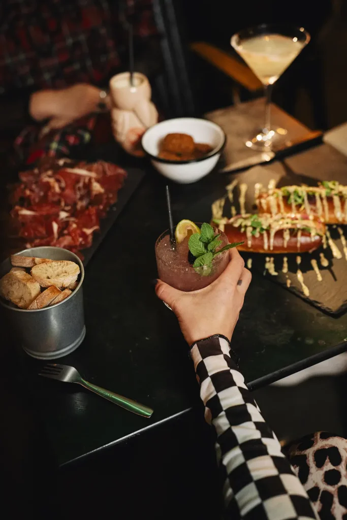 Reportage ambiance : Vue subjective d'une table d'apéro conviviale avec tapas et verres au Kubata à Bayonne, par l’agence ADIO