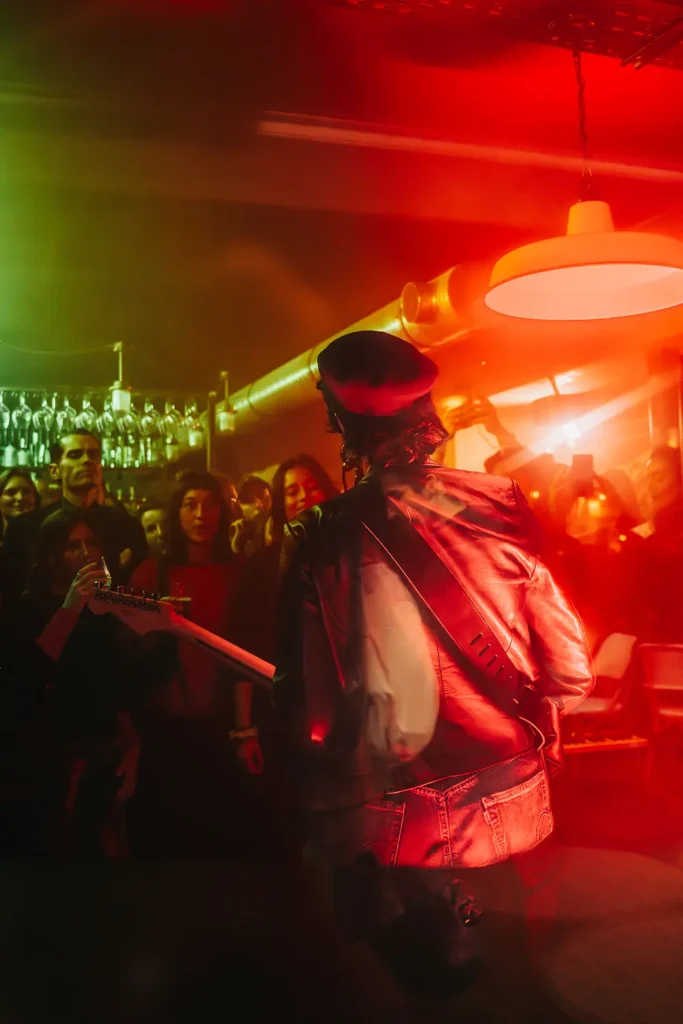 Reportage concert : vue de dos d'un guitariste jouant face à la foule au Kubata à Bayonne par l’agence ADIO.