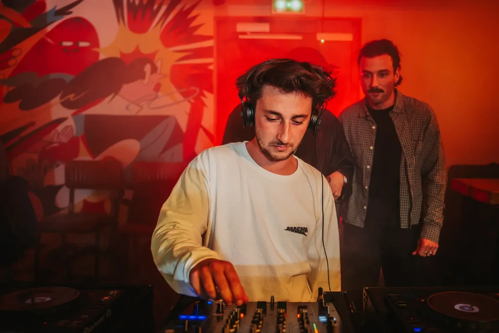 Reportage photo : DJ mixant devant une fresque murale lors d'une soirée au Kubata à Bayonne par l’agence ADIO.