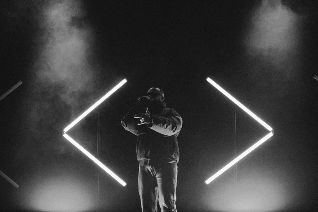 Mise en lumière artiste : Silhouette de Médine encadrée par des néons géométriques à l'Atabal Biarritz par l'agence ADIO